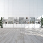 A long modular white storage cabinet and shelving unit set against a white paneled wall, with light wood flooring and potted plants on both sides.